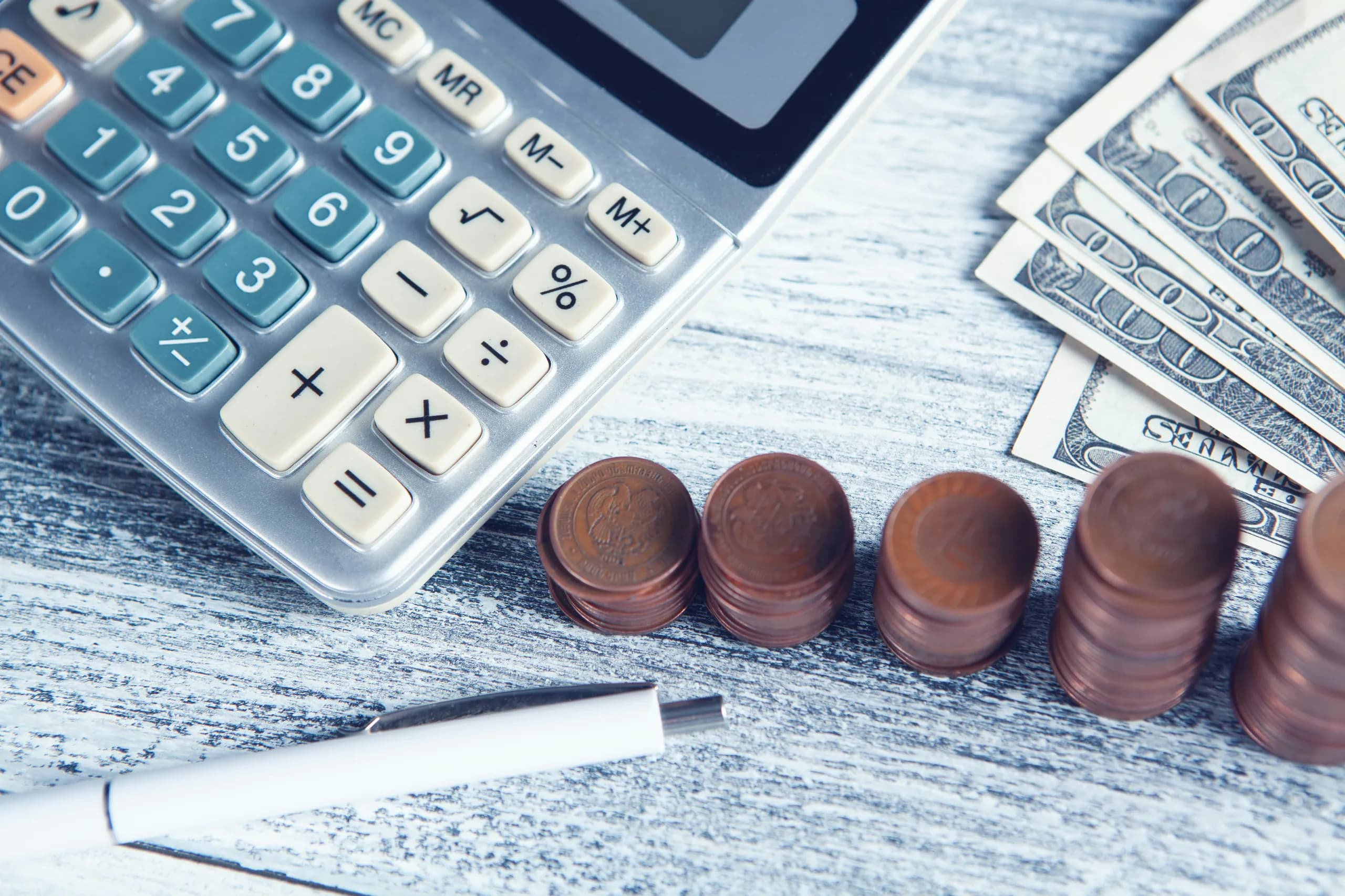 calculatrice, monnaie et stylo